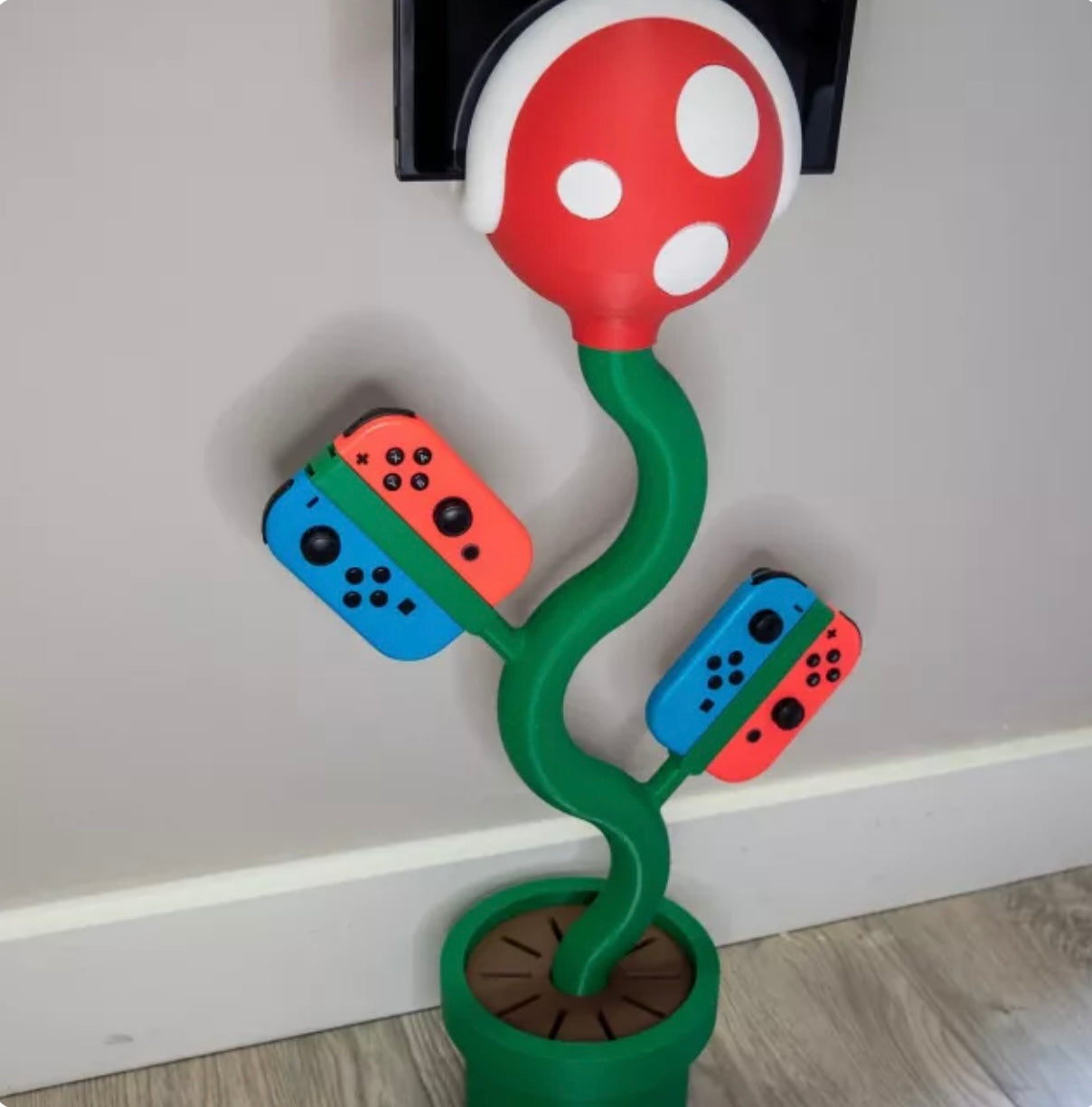 cannibal flower game console stand holding Nintendo Switch with game card slots and USB base