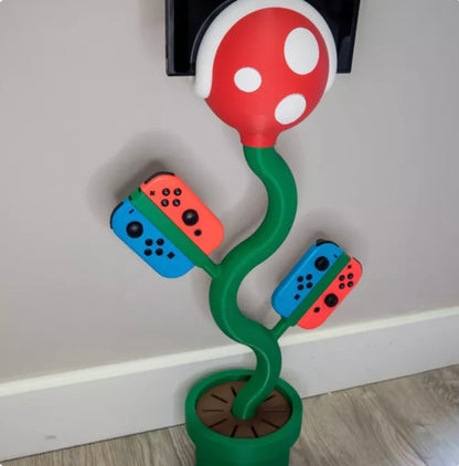 cannibal flower game console stand holding Nintendo Switch with game card slots and USB base